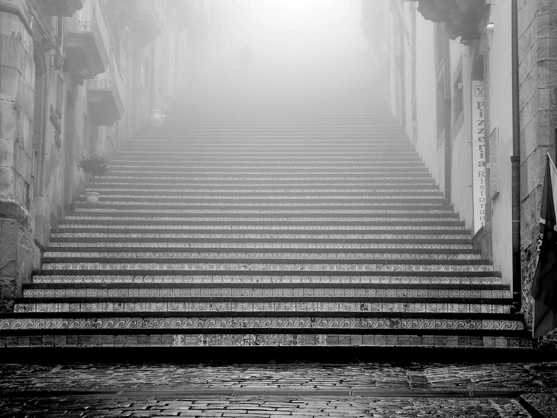 A long flight of stone steps disappearing into fog