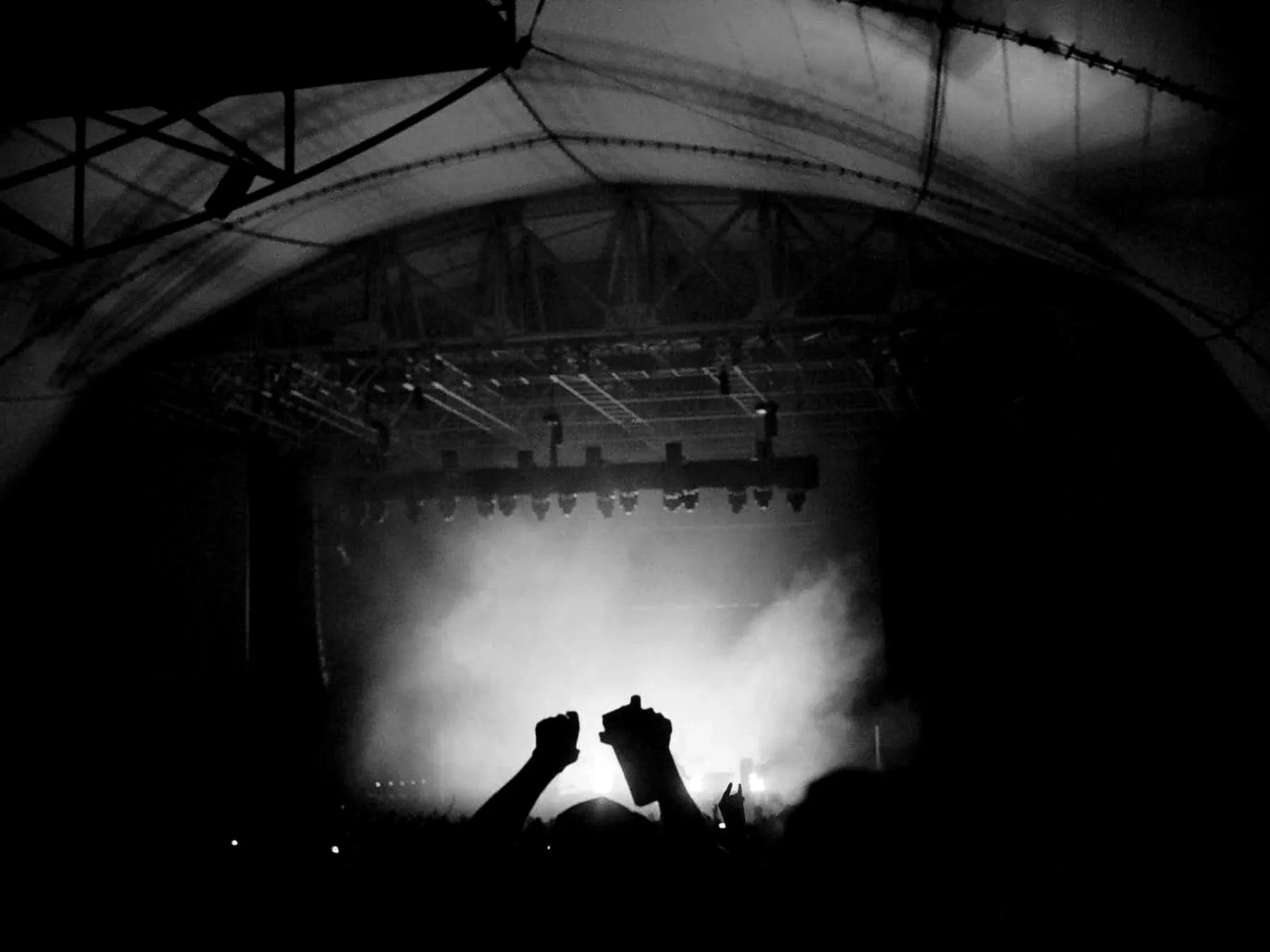 Two figures silhouetted against a blinding stage light